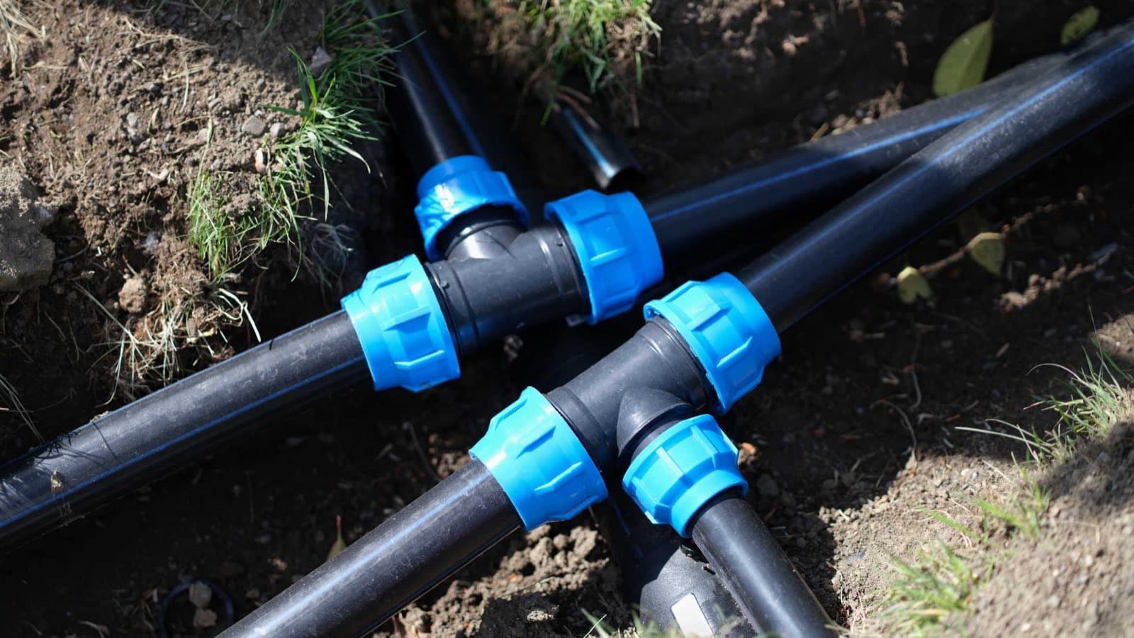New poly pipework and compression fittings being laid in a trench